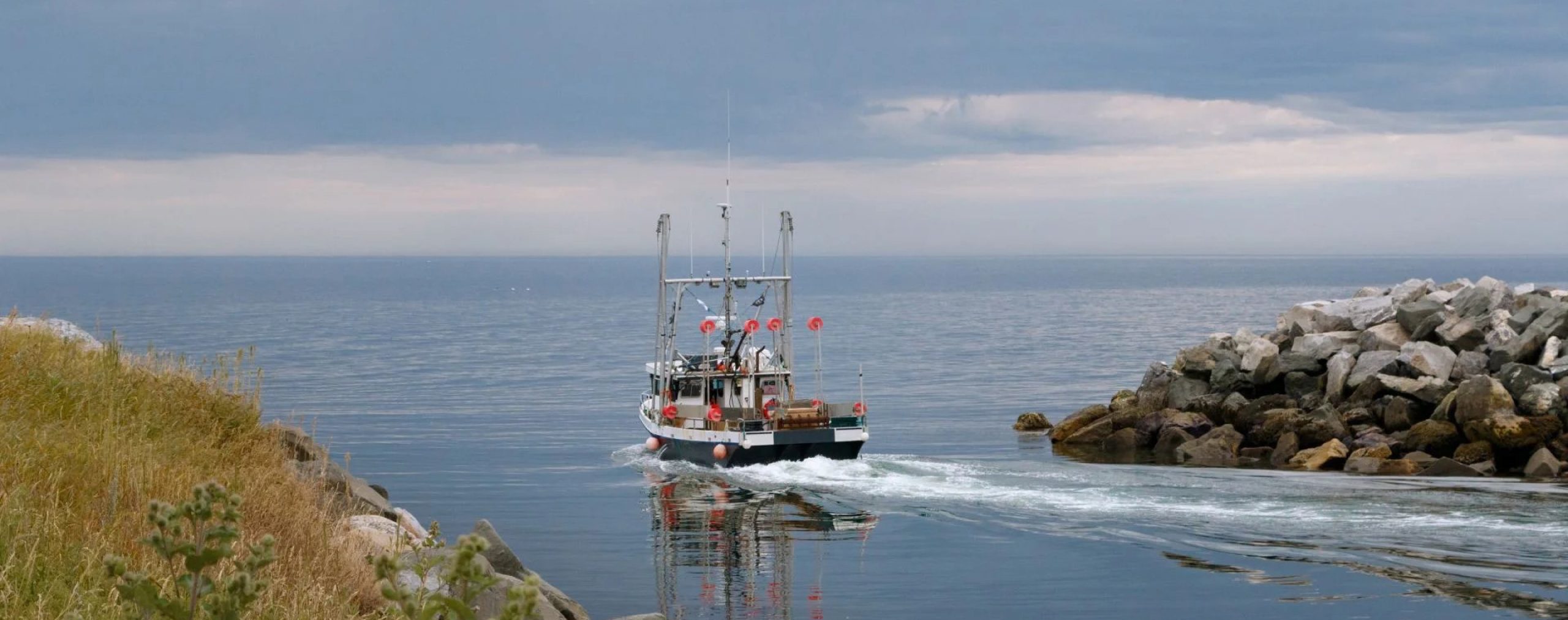 Photograph of a fishing boat leaving the shore